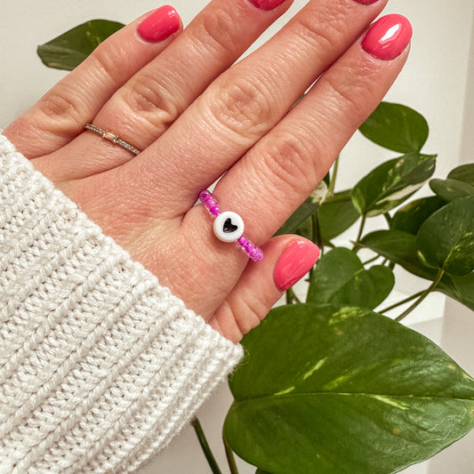 Perlenring aus lila Glasperlen mit Herz in Schwarz