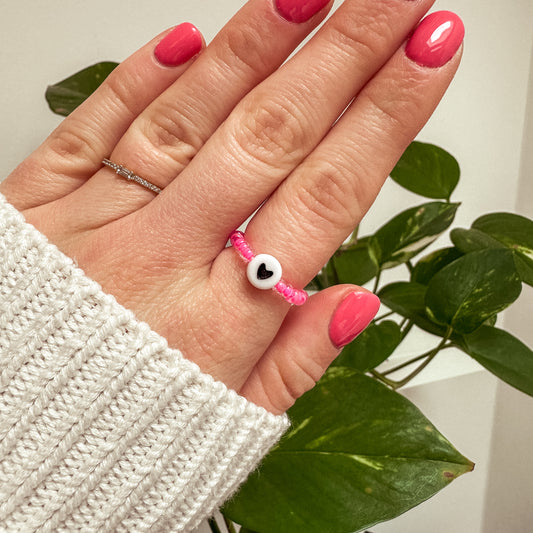 Perlenring aus pinken Glasperlen mit Herz in Schwarz