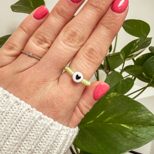 Perlenring aus gelben Glasperlen mit Herz in Schwarz