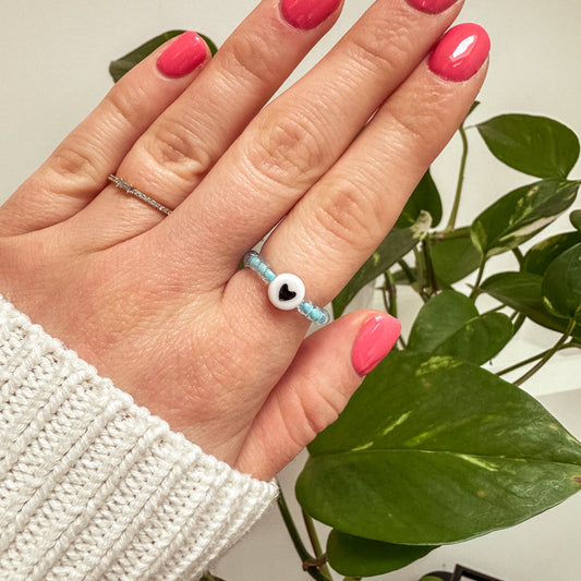 Perlenring aus blauen Glasperlen mit Herz in Schwarz