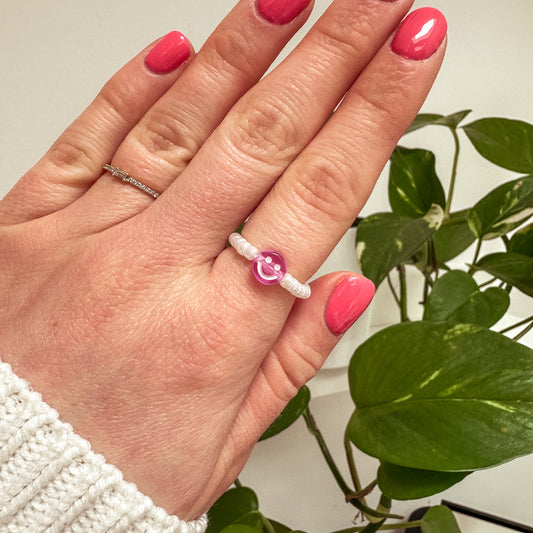 Perlenring aus weißen Glasperlen mit Smiley in Lila