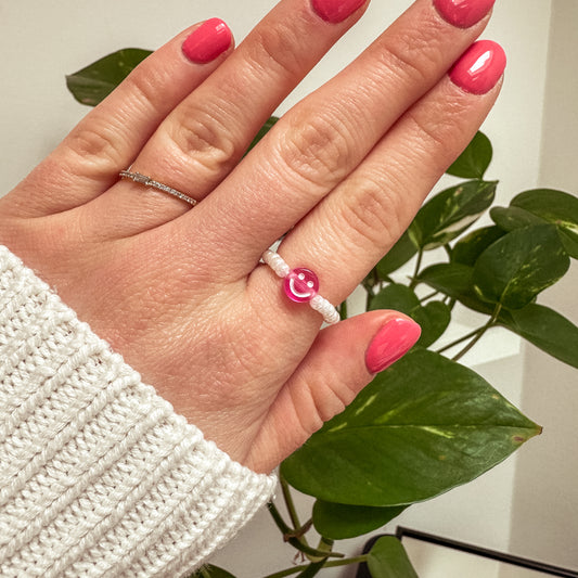 Perlenring aus weißen Glasperlen mit Smiley in Pink