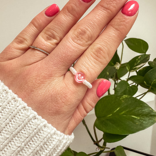 Perlenring aus weißen Glasperlen mit Smiley in Rosa