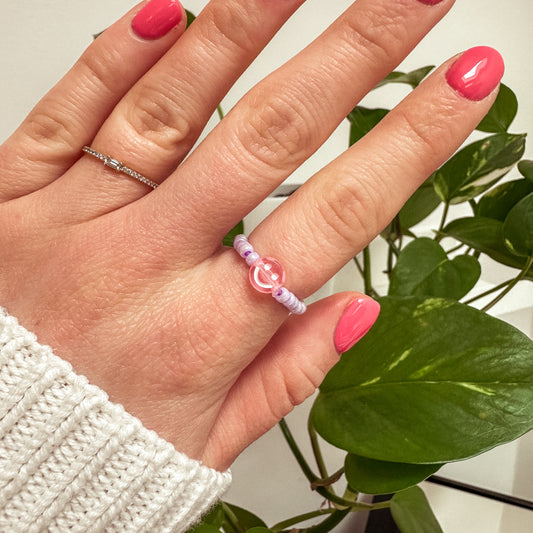 Perlenring aus Glasperlen in Flieder mit Smiley in Rosa