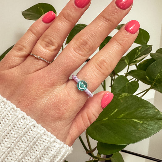 Perlenring aus Glasperlen in Flieder mit Smiley in Blau