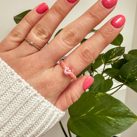 Perlenring aus Glasperlen in Apricot mit Smiley in Rosa