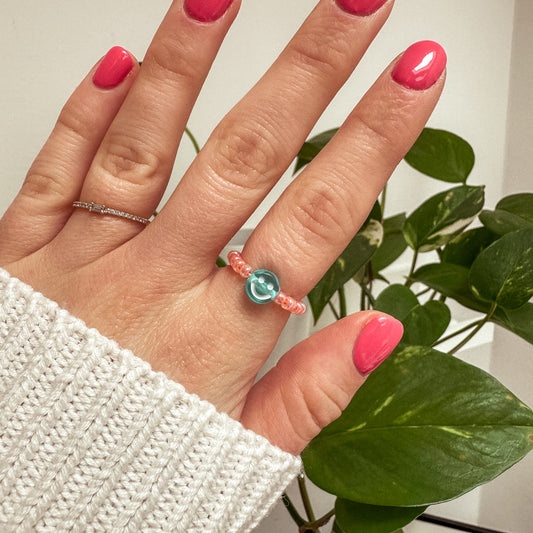 Perlenring aus Glasperlen in Apricot mit Smiley in Blau