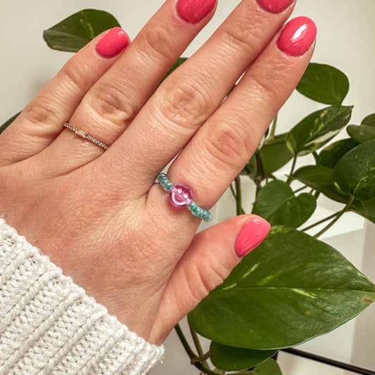 Perlenring aus Glasperlen in Aqua mit Smiley in Lila
