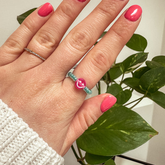 Perlenring aus Glasperlen in Aqua mit Smiley in Pink