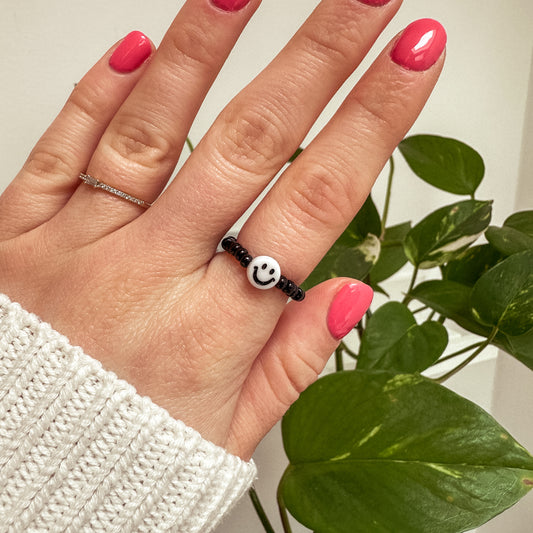 Perlenring aus schwarzen Glasperlen mit Smiley in Weiß