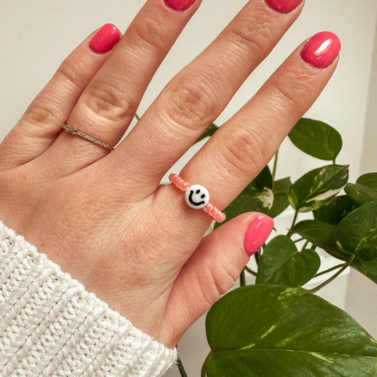 Perlenring aus Glasperlen in Apricot mit Smiley in Weiß