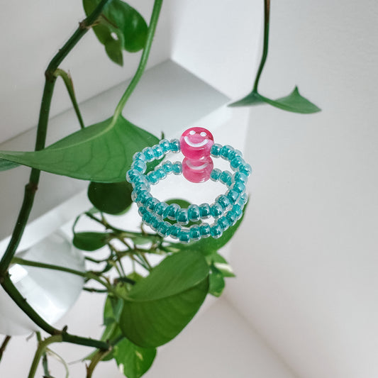 Perlenring aus Glasperlen in Aqua mit Smiley in Pink
