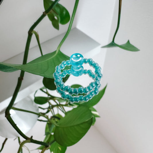 Perlenring aus Glasperlen in Aqua mit Smiley in Blau