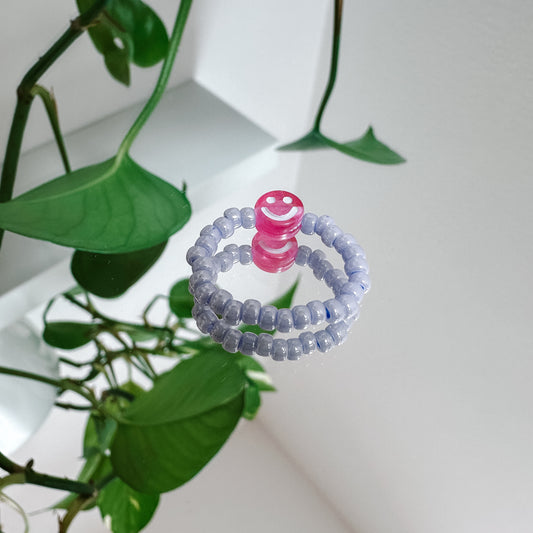 Perlenring aus Glasperlen in Flieder mit Smiley in Pink