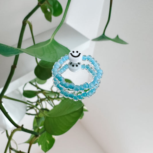 Perlenring aus Glasperlen in Neon-Blau mit Smiley in Weiß
