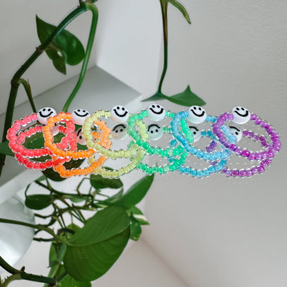 Perlenring aus Glasperlen in Neon-Lila mit Smiley in Weiß