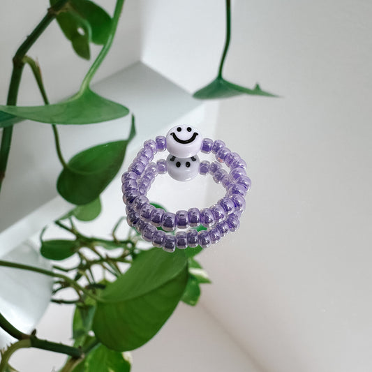Perlenring aus Glasperlen in Lavendel mit Smiley in Weiß