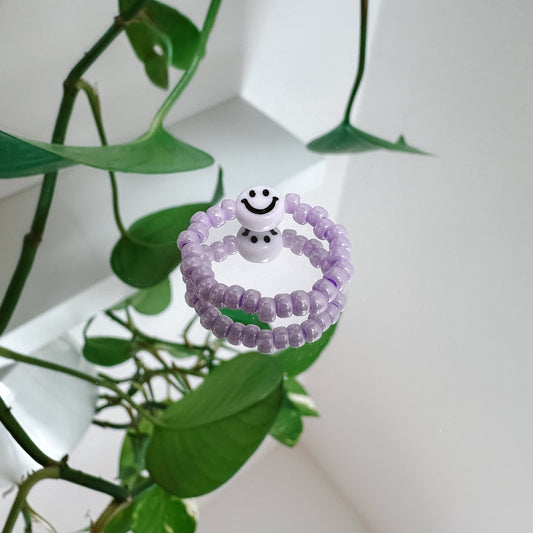 Perlenring aus Glasperlen in Flieder mit Smiley in Weiß