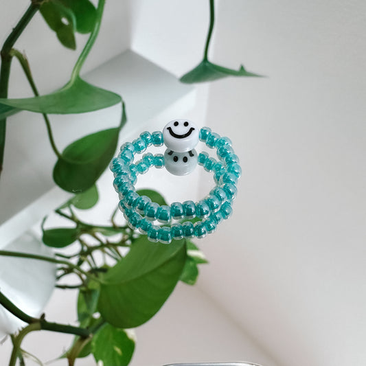 Perlenring aus Glasperlen in Aqua mit Smiley in Weiß