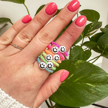 Perlenring aus Glasperlen in Neon-Lila mit Smiley in Weiß