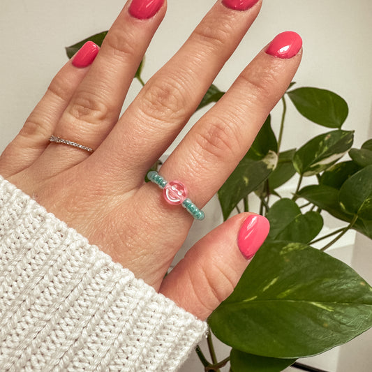 Perlenring aus Glasperlen in Aqua mit Smiley in Rosa